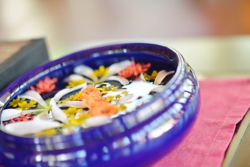 Image showing water cup with beautiful flowers background