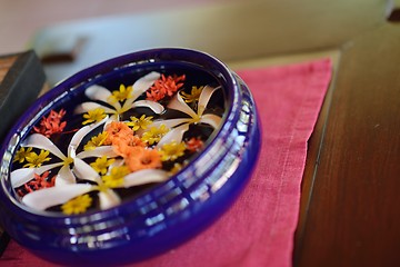 Image showing water cup with beautiful flowers background