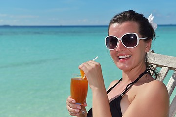 Image showing Beautiful young woman with a drink by the sea