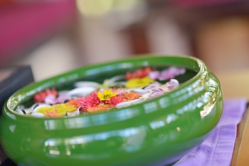 Image showing water cup with beautiful flowers background