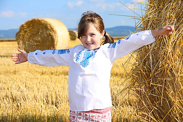 Image showing small rural girl on harvest field with straw bales