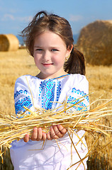 Image showing small rural girl on harvest field with straw bales
