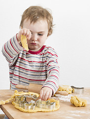 Image showing young child playing with dough on wooden desk