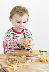 Image showing young child with dough in grey background