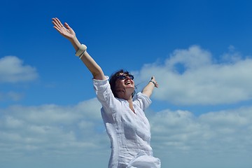 Image showing young woman with spreading arms to sky