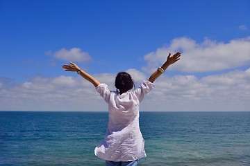 Image showing young woman with spreading arms to sky