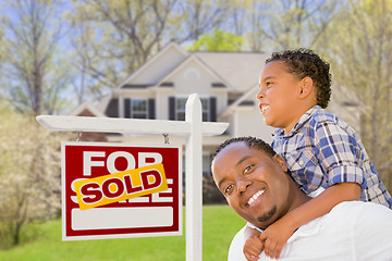 Image showing Mixed Race Father and Son In Front of Real Estate Sign and House