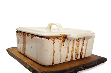 Image showing Dirty ceramic pot for stove on old kitchen board