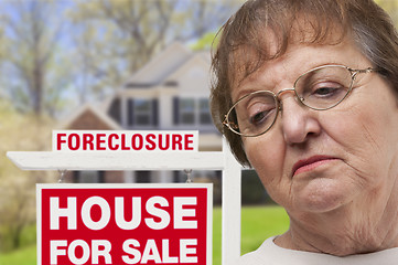 Image showing Depressed Senior Woman in Front of Foreclosure Real Estate Sign