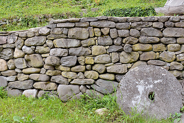 Image showing Stone wall and green grass in the backyard