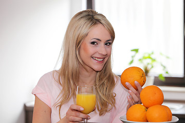 Image showing Happy woman with oranges and juice