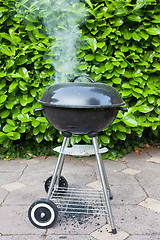 Image showing Old black barbecue being used