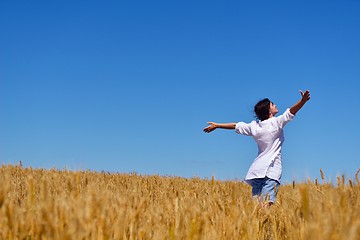 Image showing young woman with spreading arms to sky