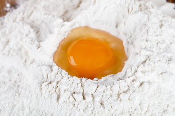 Image showing broken egg on flour 