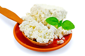 Image showing Curd in a wooden spoon and a clay plate