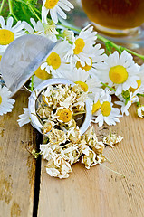 Image showing Herbal tea from chamomile dry in a strainer with cup