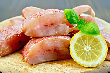 Image showing Fillet of sea bass with lemon and basil on board