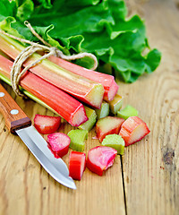 Image showing Rhubarb cut with a knife on a wooden board