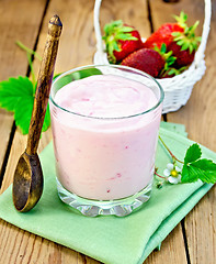 Image showing Milkshake with strawberries and spoon on the board