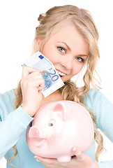 Image showing lovely woman with piggy bank and money