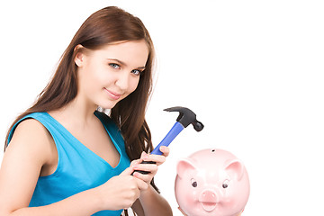 Image showing teenage girl with piggy bank and hammer