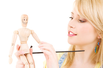 Image showing happy teenage girl with wooden model dummy