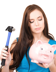 Image showing teenage girl with piggy bank and hammer