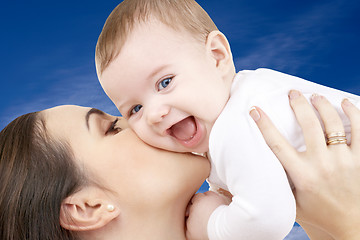 Image showing happy mother with baby boy over blue sky