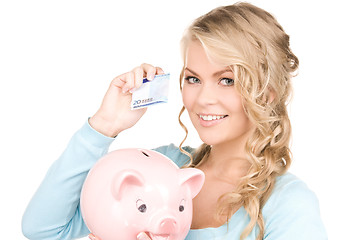 Image showing lovely woman with piggy bank and money