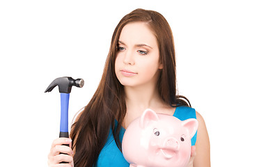 Image showing teenage girl with piggy bank and hammer