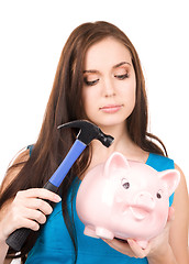 Image showing teenage girl with piggy bank and hammer