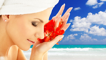 Image showing woman with flower petals over resort background