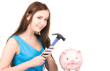 Image showing teenage girl with piggy bank and hammer