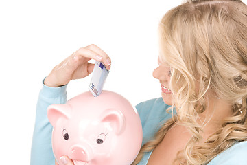 Image showing lovely woman with piggy bank and money