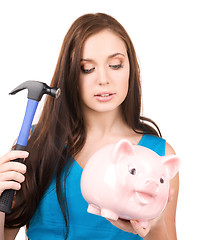 Image showing teenage girl with piggy bank and hammer