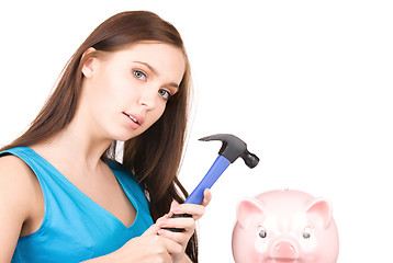 Image showing teenage girl with piggy bank and hammer