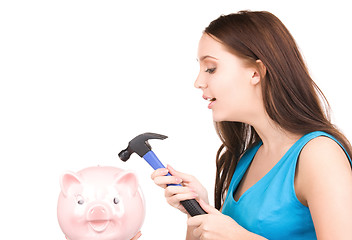 Image showing teenage girl with piggy bank and hammer