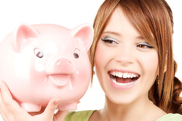 Image showing lovely teenage girl with piggy bank