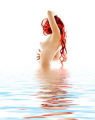 Image showing topless redhead in blue water