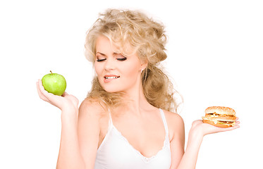 Image showing woman choosing between burger and apple