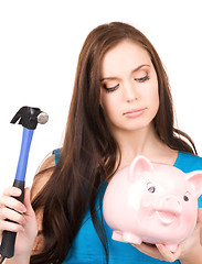 Image showing teenage girl with piggy bank and hammer