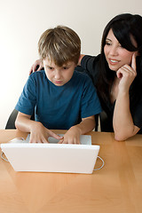 Image showing Child using laptop while adult supervises