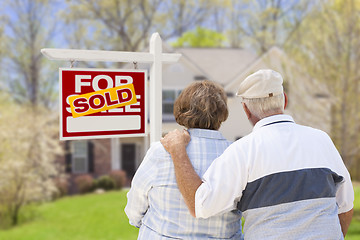 Image showing Senior Couple in Front of Sold Real Estate Sign and House