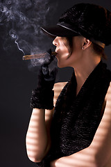 Image showing woman in black astrakhan smoking cigar