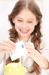 Image showing little girl with piggy bank and money