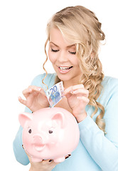 Image showing lovely woman with piggy bank and money