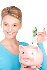 Image showing lovely woman with piggy bank and money