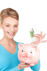 Image showing lovely woman with piggy bank and money