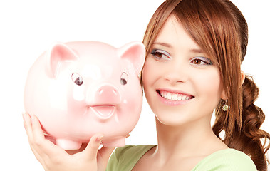 Image showing lovely teenage girl with piggy bank