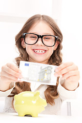 Image showing little girl with piggy bank and money